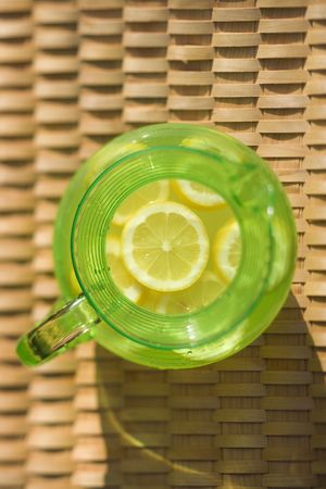 Overview of green plastic pitcher of lemonade with sliced lemons.の写真素材