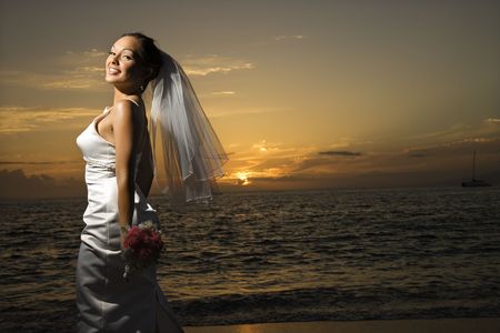 Young adult female Caucasian bride on beach.の写真素材