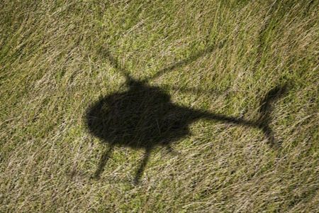 Helicopter shadow over green grassy field in Maui, Hawaii.の写真素材