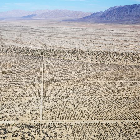 Aerial view of remote California desert with grid pattern and mountain range in background.の写真素材