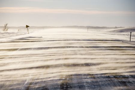 Ice covered road with snow being blown over.の写真素材