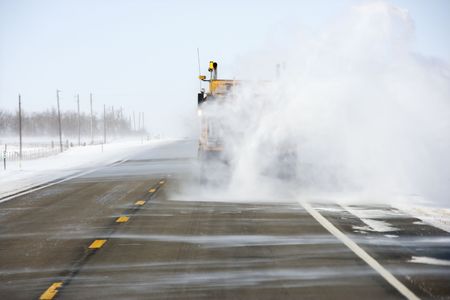 Truck on road trailing snow behind.の写真素材