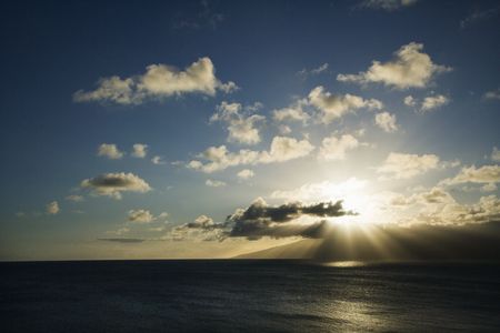 Pacific ocean and island with sun streaming through clouds.の写真素材
