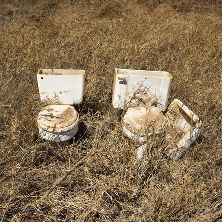 Old toilets that were dumped in field.の写真素材