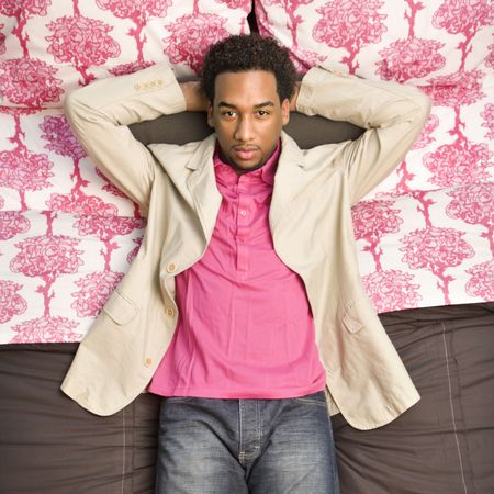 African American male laying on bed looking at viewer.の写真素材