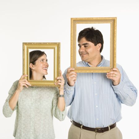 Man and woman looking through empty frames.の写真素材