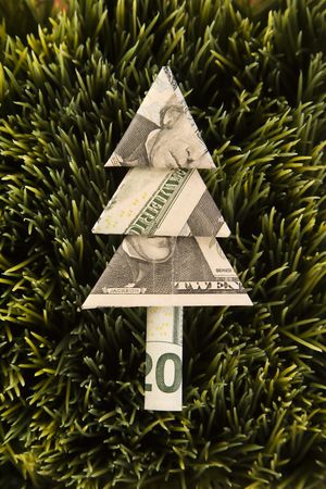 Studio shot of origami tree made from a twenty dollar bill placed in grass.の写真素材