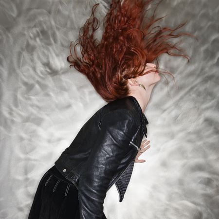 Side view of Caucasian young woman flipping hair into air.の写真素材