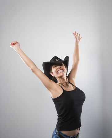 Portrait of woman smiling and holding arms up in air.の写真素材