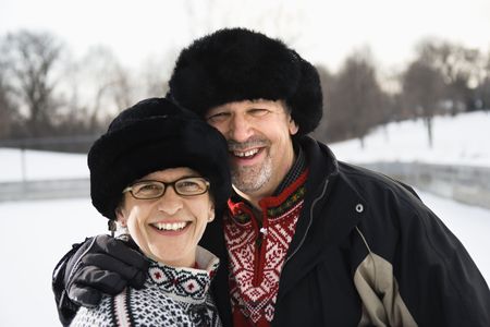 Portrait of Caucasian middle aged man and woman wearing  black winter hats smiling at viewer.の写真素材