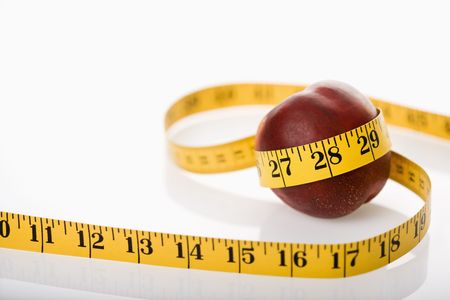 Measuring tape wrapped around nectarine.の写真素材