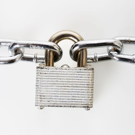 Metal padlock locked to chains.の写真素材
