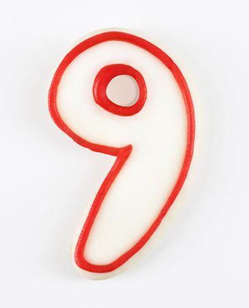 Sugar cookie in the shape of a number nine outlined in red icing.の写真素材