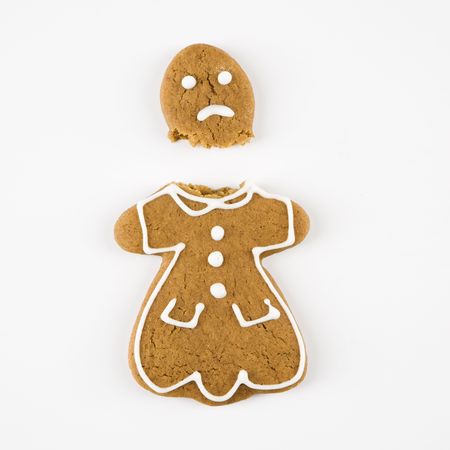 Frowning female gingerbread cookie broken in half.の写真素材