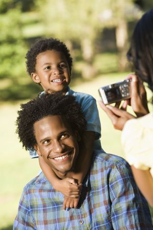 Father and son in park being photographed with digital camera.の写真素材