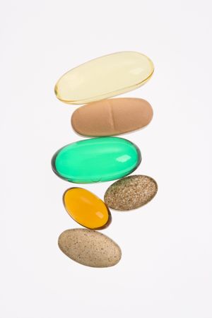 Close up of supplement vitamin pills against white background.の写真素材