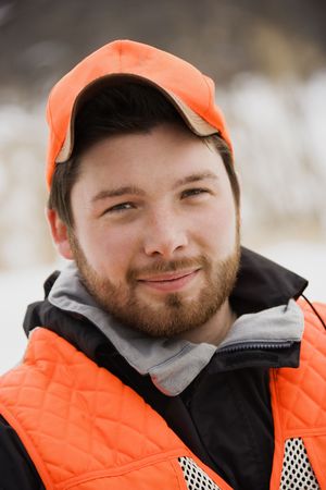 Portrait of young mid-adult male wearing blaze orange safety hunting clothing.