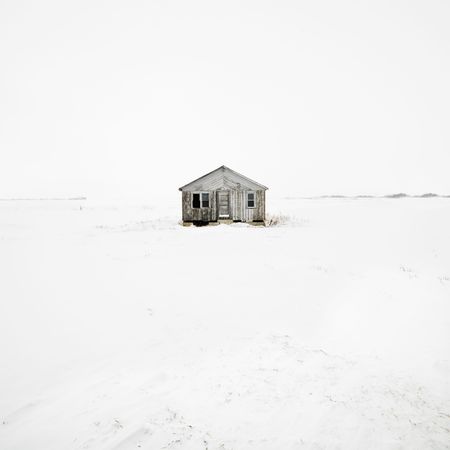 Abandoned house in snow covered landscape.の写真素材