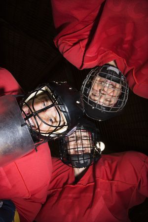 Low angle of female hockey players in huddle smiling.の写真素材