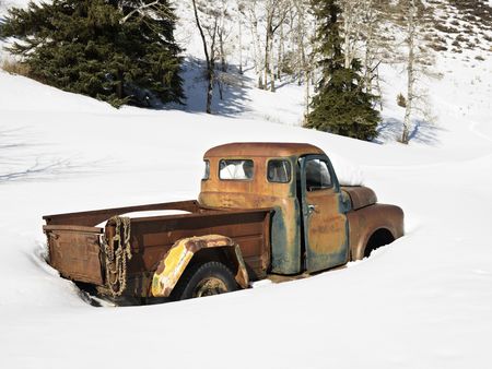 Old rusted classic truck in snow covered field. の写真素材