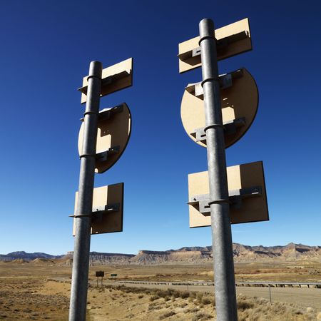 Two road signs on a psot with guardrail and mountains in background.の写真素材