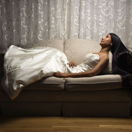 Portrait of an Indian bride lying on love seat.の写真素材