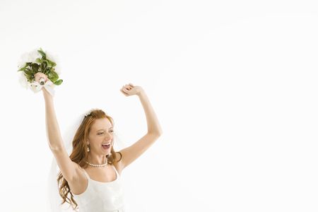 Portrait of Caucasian bride holding bouquet and raising arms.の写真素材