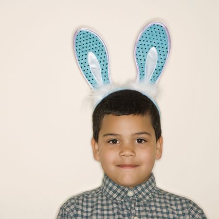 Portrait of Hispanic boy wearing bunny ears looking at viewer.の写真素材