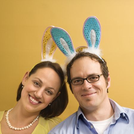 Caucasian mid adult couple wearing rabbit ears and looking at viewer.の写真素材