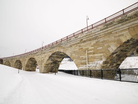 Scene of stone bridge over over snow covered road.の写真素材