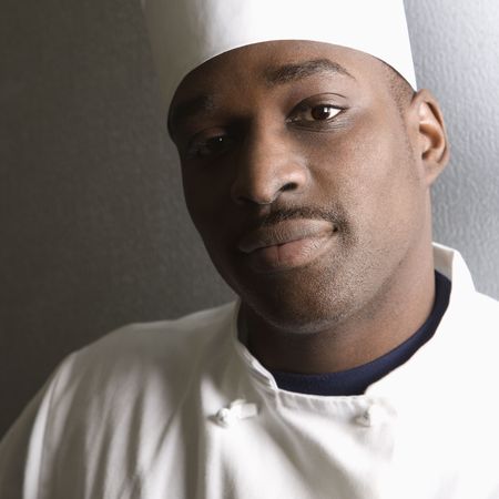 Head shot of African-American male chef wearing traditional uniform and toque looking at viewer.の写真素材