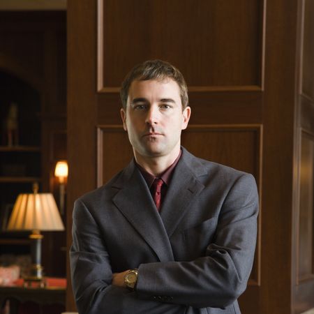 Caucasian mid adult businessman looking at viewer with arms crossed.