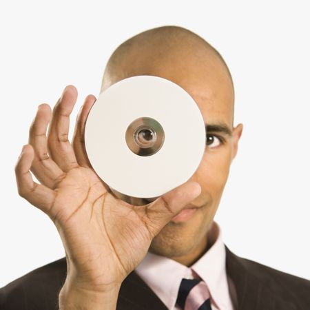 African American man holding compact disc over face and peeking through hole.の写真素材