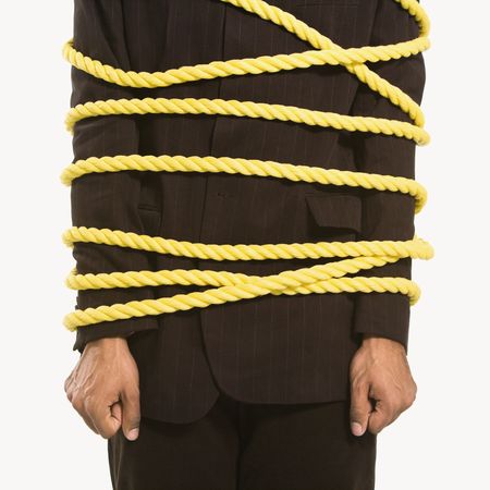 African American businessman wrapped in yellow rope.の写真素材