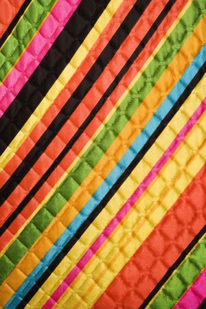 Close-up of bright colorful striped quilted vintage fabric.