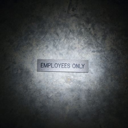 Metal employees only sign on textured background.の写真素材