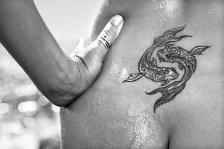 Close up of  wet Caucasian mid adult womans tattoo of koi fish on lower back.の写真素材