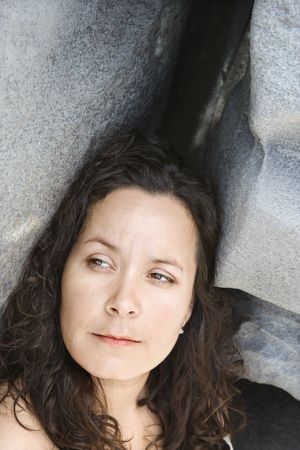 Portrait of brunette Caucasian mid-adult woman by rock formation.の写真素材