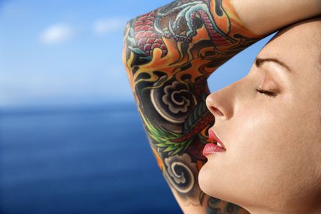 Close up portrait of tattooed woman with Pacific Ocean in background in Maui, Hawaii, USA.の写真素材