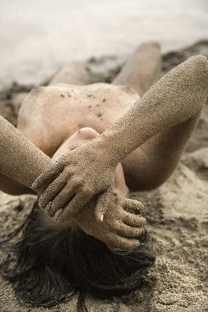 Sexy Caucasian young adult nude woman lying on beach.の写真素材