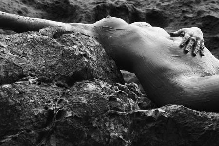 Young adult Caucasian female nude lying on rocky coast of Maui, Hawaii.の写真素材