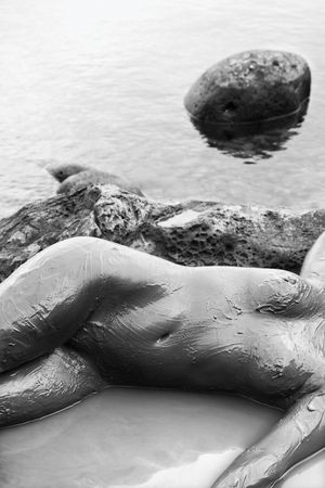 Young adult Caucasian female nude lying on rocky coast of Maui, Hawaii.の写真素材