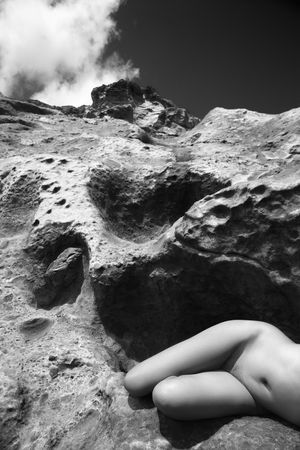 Young Asian  woman lying on side on rock.の写真素材