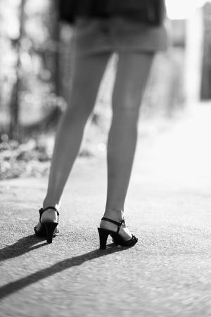 Legs of Caucasian mid-adult woman wearing blue jean skirt and heels.の写真素材