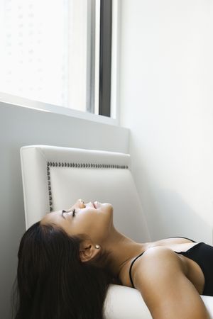 Profile of Hispanic young adult woman lying on her back with eyes closed.の写真素材