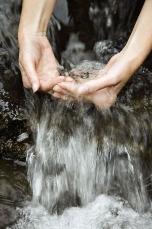 Caucasian young adult female hands washing in pure clean fresh water.の写真素材