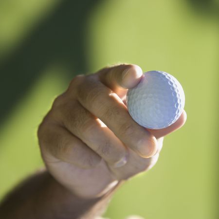 Caucasian mid adult male hand holding golf ball.の写真素材