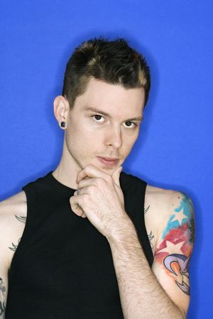 Young adult Caucasian male pierced ear and tattoo.の写真素材