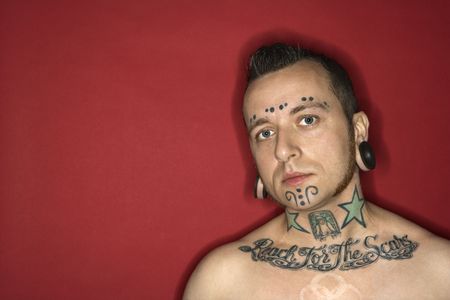 Caucasian mid-adult man with tattoos and piercings.の写真素材