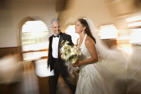 Bride and groom leaving church with motion blur effect.の写真素材